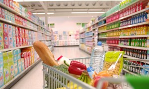 Supermarket trolley filled with vegetables in aisle